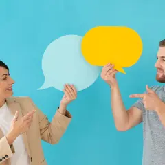Hombre y mujer con bocadillos de diálogo, discutiendo ideas. Sonrisas y gestos sugieren técnicas para no entrar al trapo en una conversación.