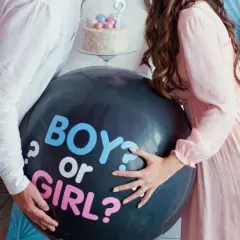 Pareja celebra un gender reveal, con un globo negro que pregunta "BOY or GIRL?".