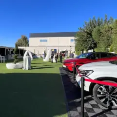 Un roadshow que es: coches nuevos en exposición al aire libre, con stands y gente paseando.