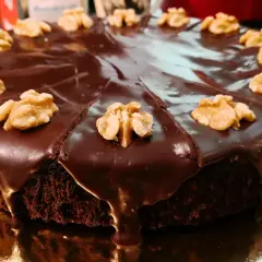 Pastel de chocolate cubierto de glaseado brillante y nueces, perfecto para ideas de cumpleaños de 16 años.