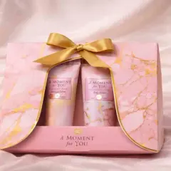 Un set de regalo rosa con mármol dorado y un lazo dorado, perfecto para el día de la madre. Contiene lociones "A Moment for You".