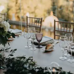 Mesa de boda romántica vintage con flores, copas de cristal y panecillos.