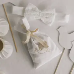 Detalles para un bautizo: zapatos de bebé, diadema de encaje, bolsita bordada y palomas. Ideas para donde celebrar bautizo.
