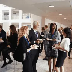 Profesionales conversan y disfrutan de un cóctel en un evento corporativo. Ejemplos de networking y colaboración.