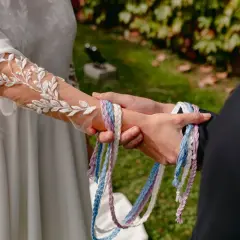 Manos unidas por cintas de colores, un hermoso simbolo matrimonio.