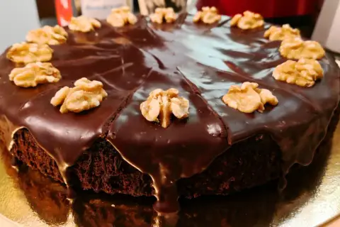 Pastel de chocolate cubierto de glaseado brillante y nueces, perfecto para ideas de cumpleaños de 16 años.