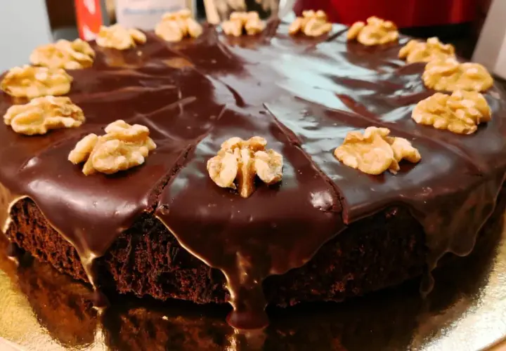 Pastel de chocolate cubierto de glaseado brillante y nueces, perfecto para ideas de cumpleaños de 16 años.