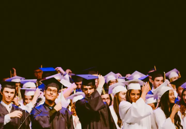 Estudiantes celebran su graduación universitaria, ajustándose togas y birretes.