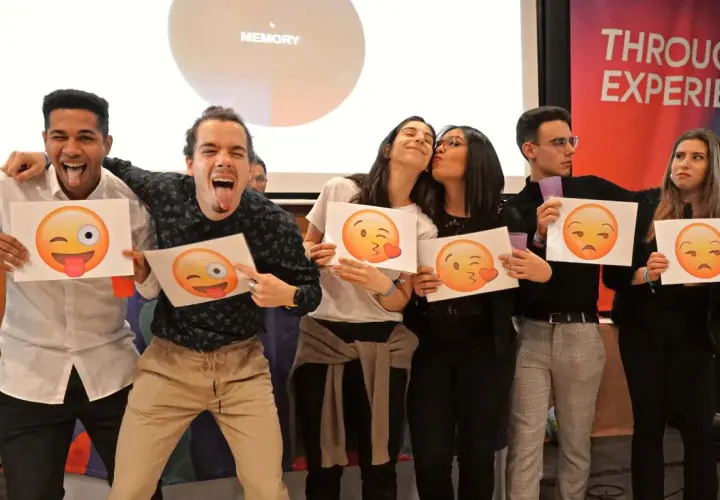 Jóvenes celebrando fiestas de empresa con emojis. Unos hacen muecas, otros se dan besos, y otros muestran caras de enfado.