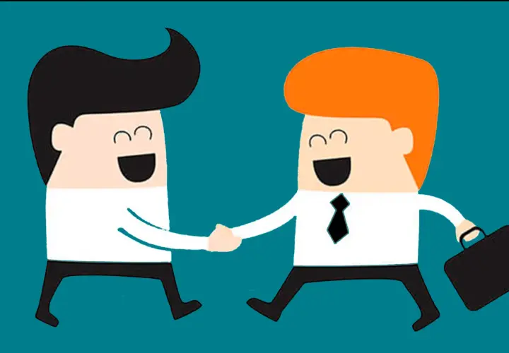 Dos hombres de negocios sonríen y se dan la mano, mostrando asertividad positiva en un acuerdo.