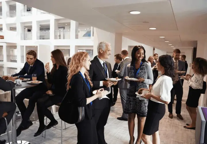 Profesionales conversan y disfrutan de un cóctel en un evento corporativo. Ejemplos de networking y colaboración.