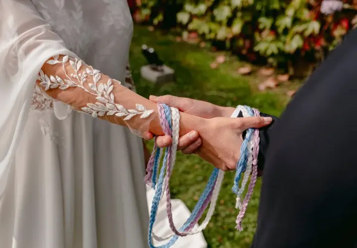 Manos unidas por cintas de colores, un hermoso simbolo matrimonio.