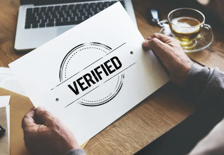 Man holding a paper with "VERIFIED" stamp, symbolizing a certificado profesionalidad online.