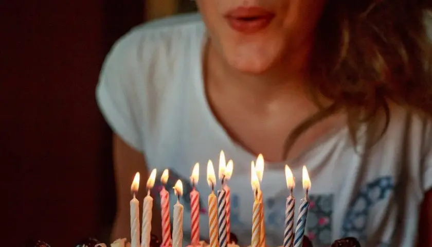 Niña soplando velas en un pastel. ¡Una idea genial para celebrar qué hacer en tu cumpleaños!