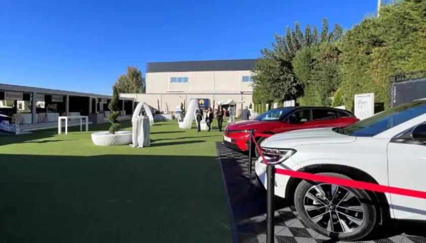 Un roadshow que es: coches nuevos en exposición al aire libre, con stands y gente paseando.