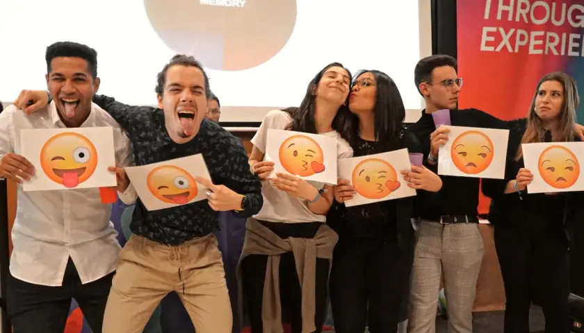 Jóvenes celebrando fiestas de empresa con emojis. Unos hacen muecas, otros se dan besos, y otros muestran caras de enfado.