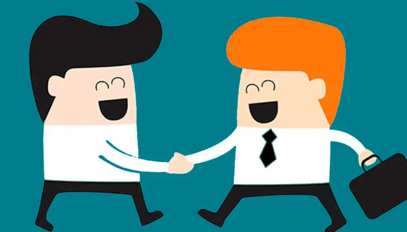 Dos hombres de negocios sonríen y se dan la mano, mostrando asertividad positiva en un acuerdo.