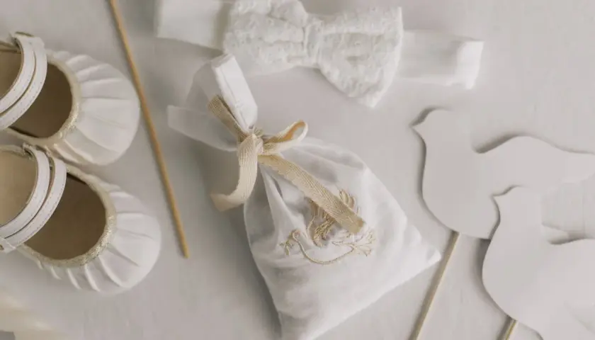 Detalles para un bautizo: zapatos de bebé, diadema de encaje, bolsita bordada y palomas. Ideas para donde celebrar bautizo.