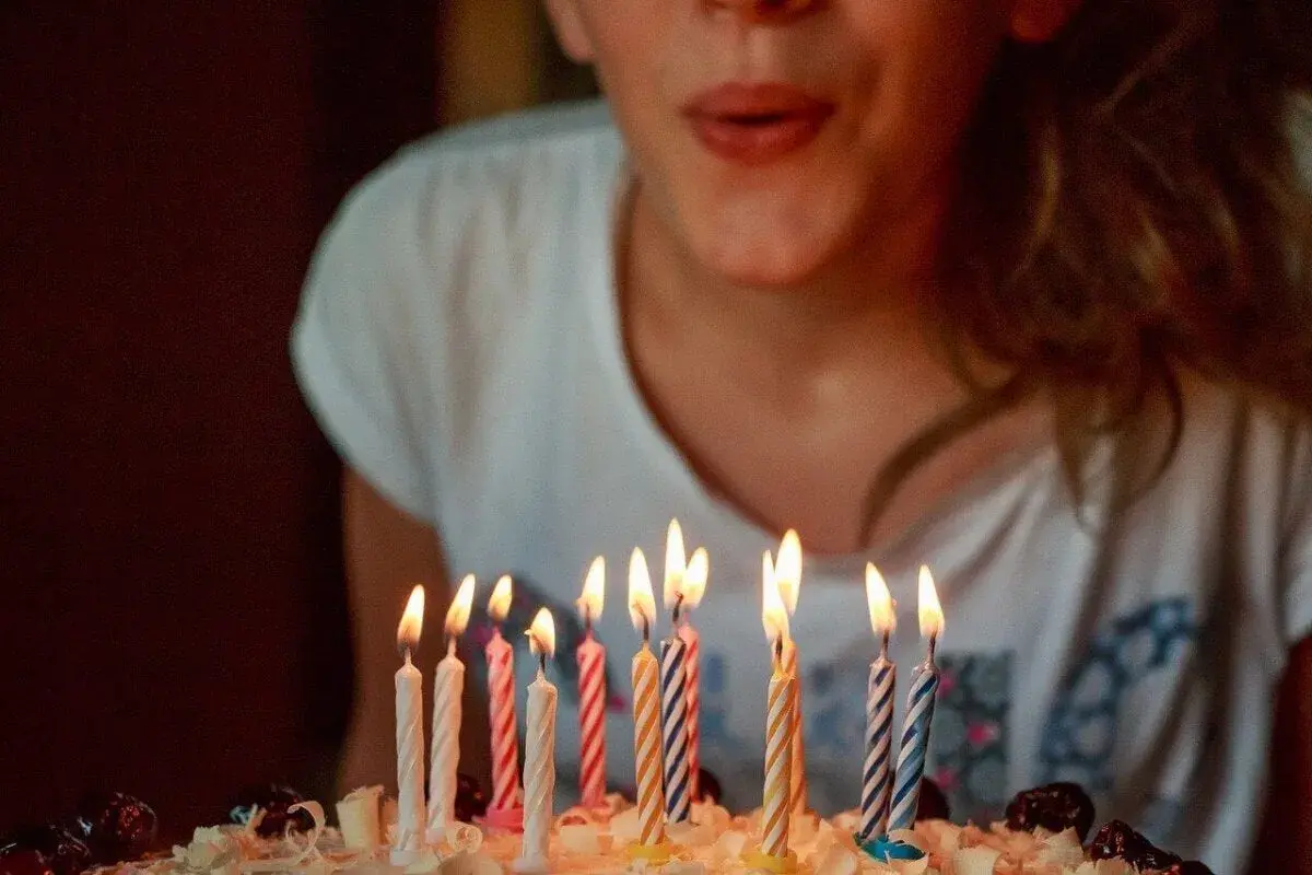 Niña soplando velas en un pastel. ¡Una idea genial para celebrar qué hacer en tu cumpleaños!