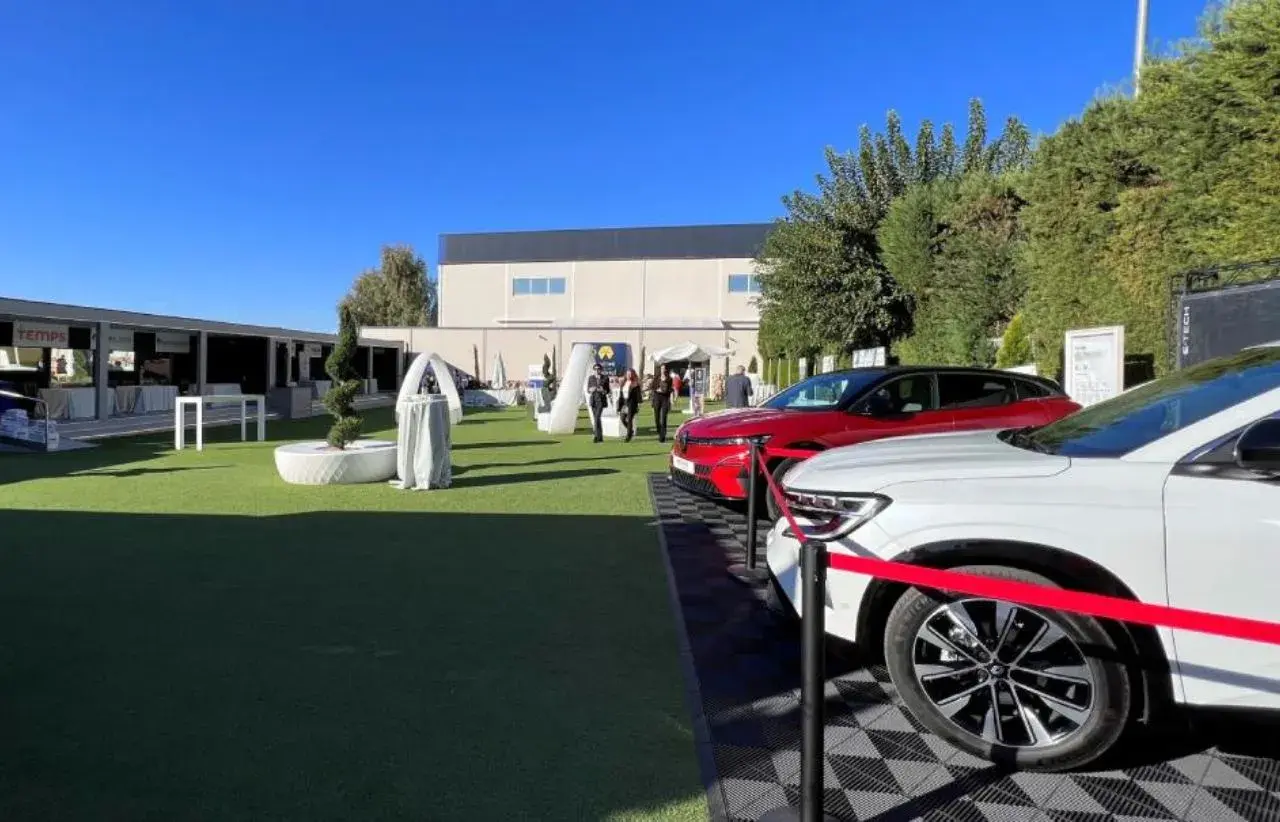 Un roadshow que es: coches nuevos en exposición al aire libre, con stands y gente paseando.