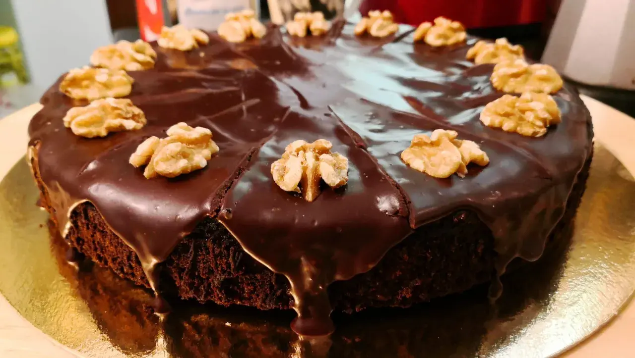 Pastel de chocolate cubierto de glaseado brillante y nueces, perfecto para ideas de cumpleaños de 16 años.