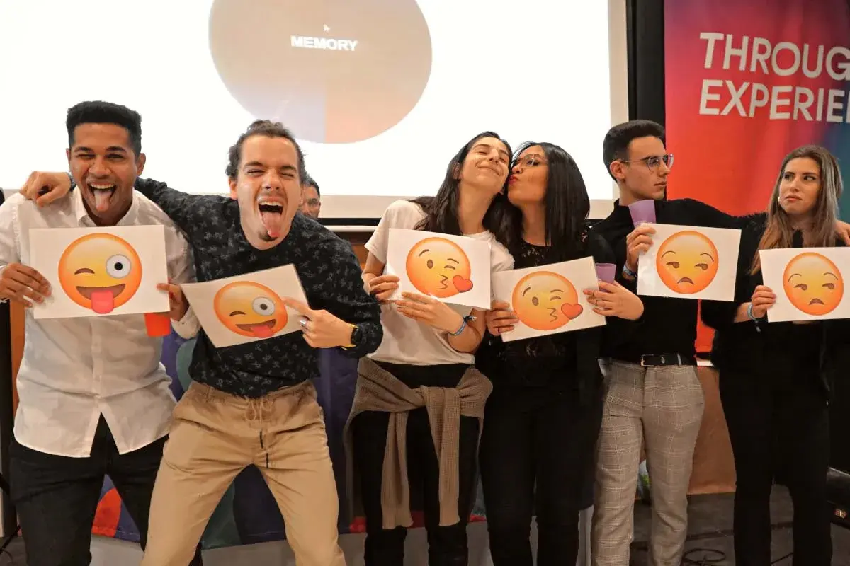 Jóvenes celebrando fiestas de empresa con emojis. Unos hacen muecas, otros se dan besos, y otros muestran caras de enfado.