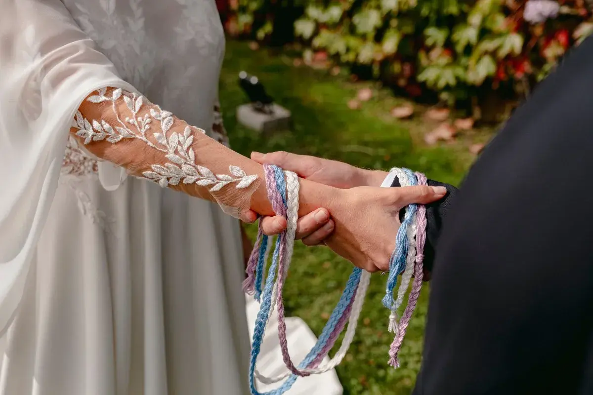 Manos unidas por cintas de colores, un hermoso simbolo matrimonio.