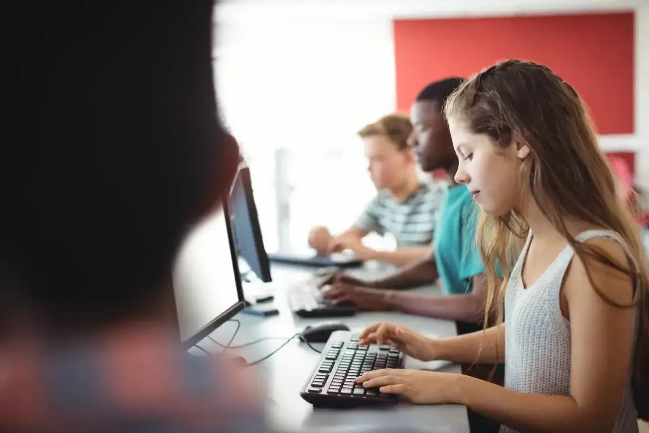 Estudiantes aprenden en un curso de secretariado administrativo, concentrados en sus teclados.