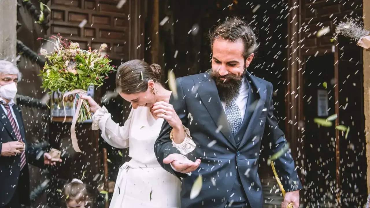 Novios felices, cubiertos de p&eacute;talos, celebrando sus bodas a los 20 a&ntilde;os. Un d&iacute;a lleno de alegr&iacute;a y amor.