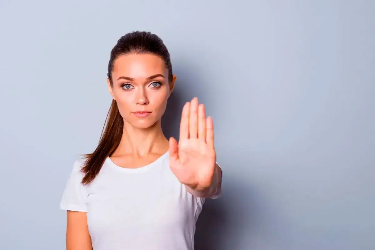 Mujer con mano extendida, mostrando c&oacute;mo saber decir no. Ejemplos de l&iacute;mites claros.