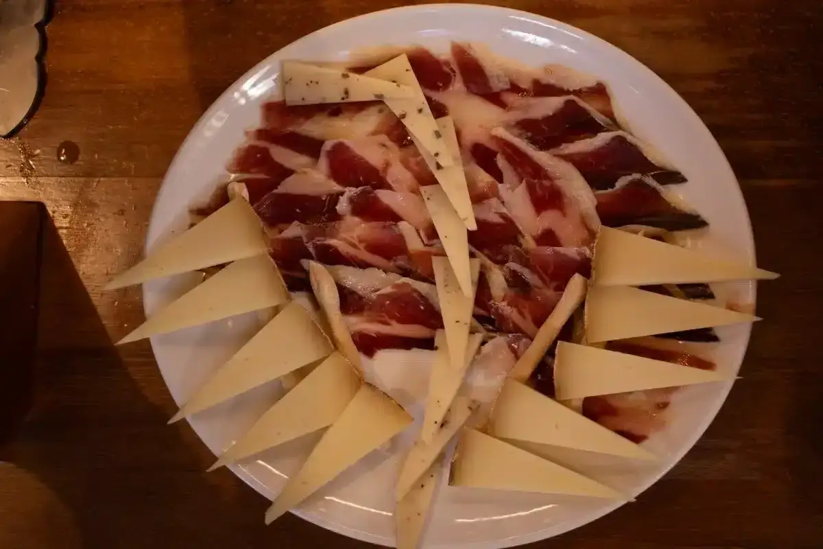 Plato de jamón serrano y queso en cuña, perfecto como aperitivos para bodas.