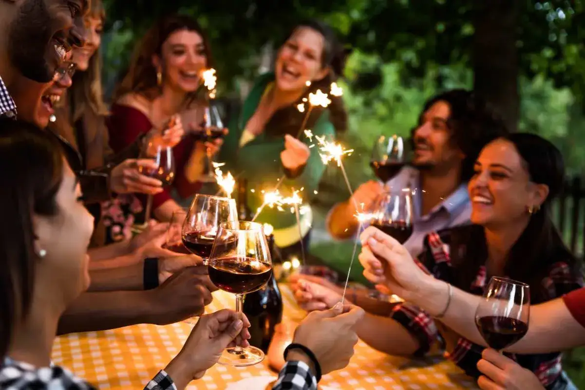 Amigos celebran con vino y bengalas. &iexcl;Una idea genial para saber qu&eacute; hacer en tu cumplea&ntilde;os!