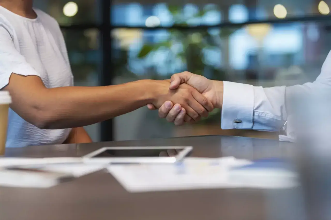Dos personas se dan la mano, simbolizando un acuerdo o inicio de colaboraci&oacute;n, quiz&aacute;s tras un curso de mediaci&oacute;n gratis.