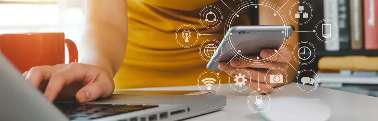 Persona interactuando con un smartphone y portátil, rodeada de iconos de conectividad y datos. Ideal para un curso de analítica digital.
