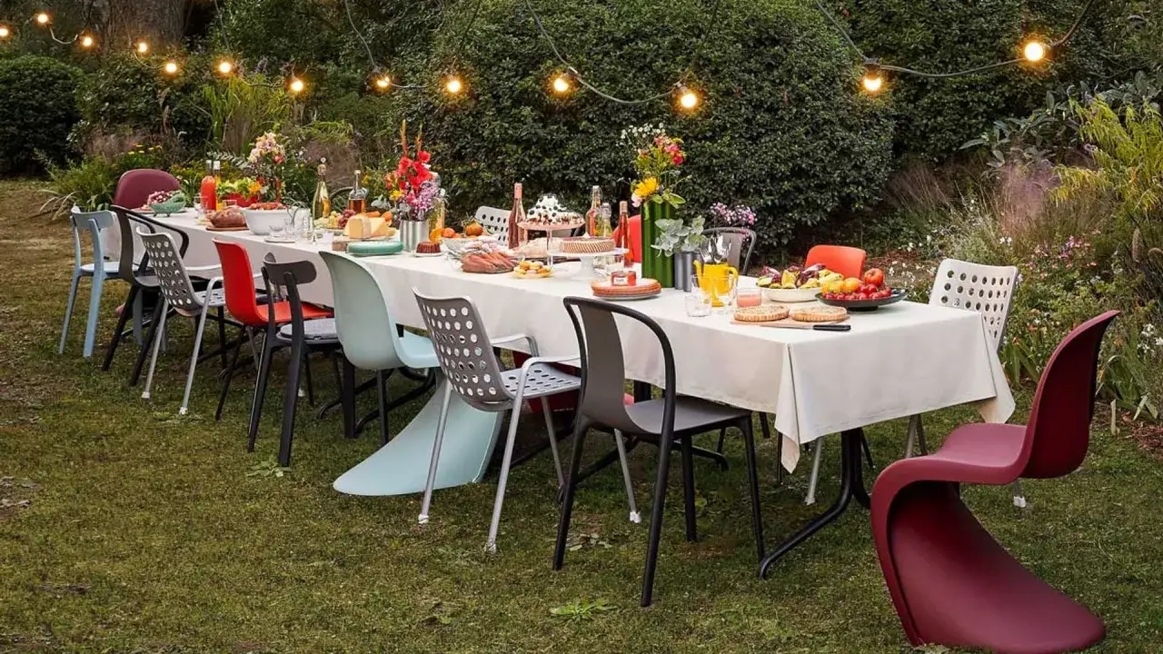 Mesa puesta para adultos, ideas para cumpleaños al aire libre fáciles. Comida, flores y luces decoran el jardín.