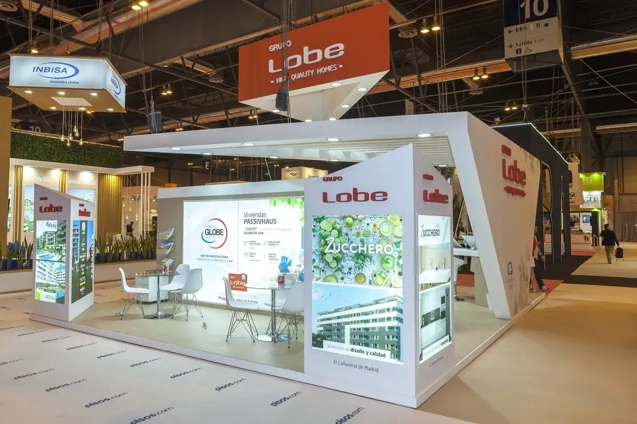 Expositor de viviendas de diseño y calidad en una feria comercial. Destacan los logos de