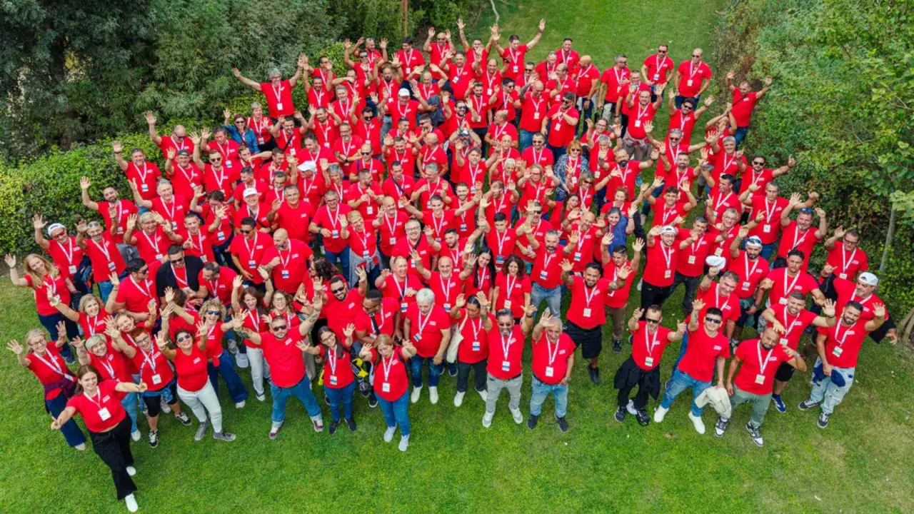 Grupo grande de personas con camisetas rojas, celebrando al aire libre. &iexcl;Unas de las mejores actividades team building originales!
