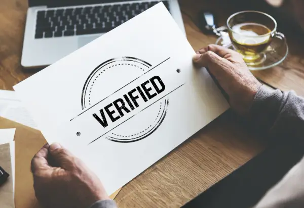 Man holding a paper with "VERIFIED" stamp, symbolizing a certificado profesionalidad online.