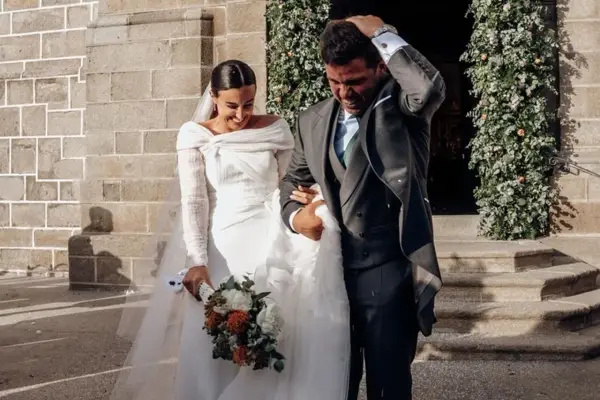 Novios saliendo de la iglesia, ella con un vestido elegante y él con traje, mostrando diferentes estilos de boda.